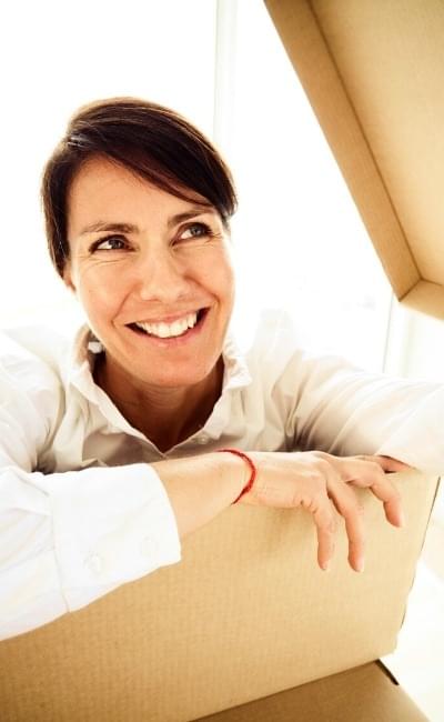smiling woman climbing out of box